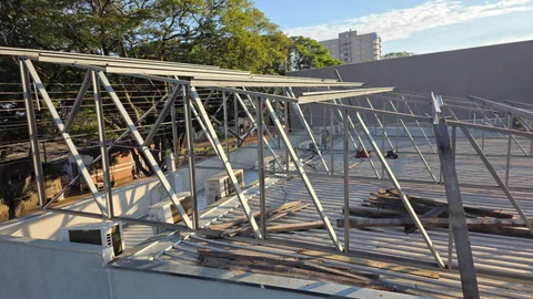 Estrutura metálica de suporte em montagem acima de um telhado