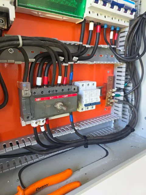 Cabeamento e disjuntores organizados no interior de quadro elétrico